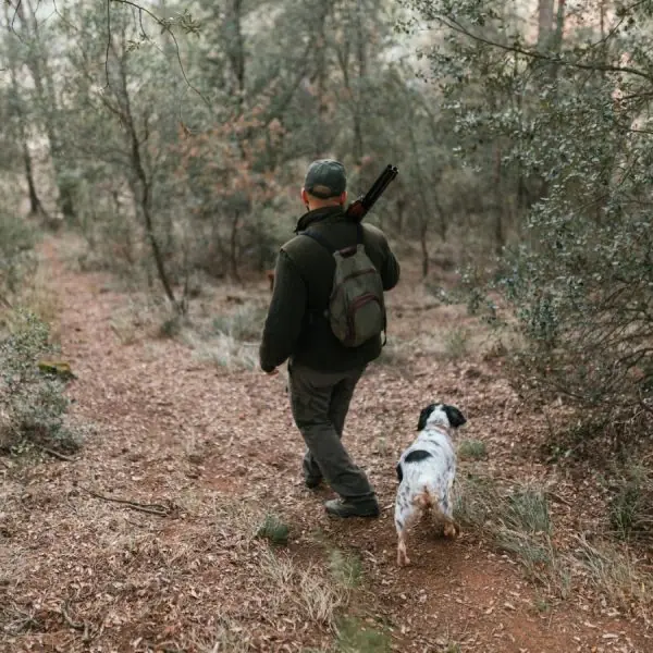 Home 51 Man hunting with dog in dense forest